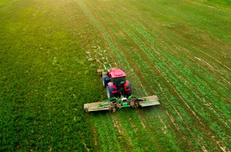 a tractor mows a field of aerial photography with drone